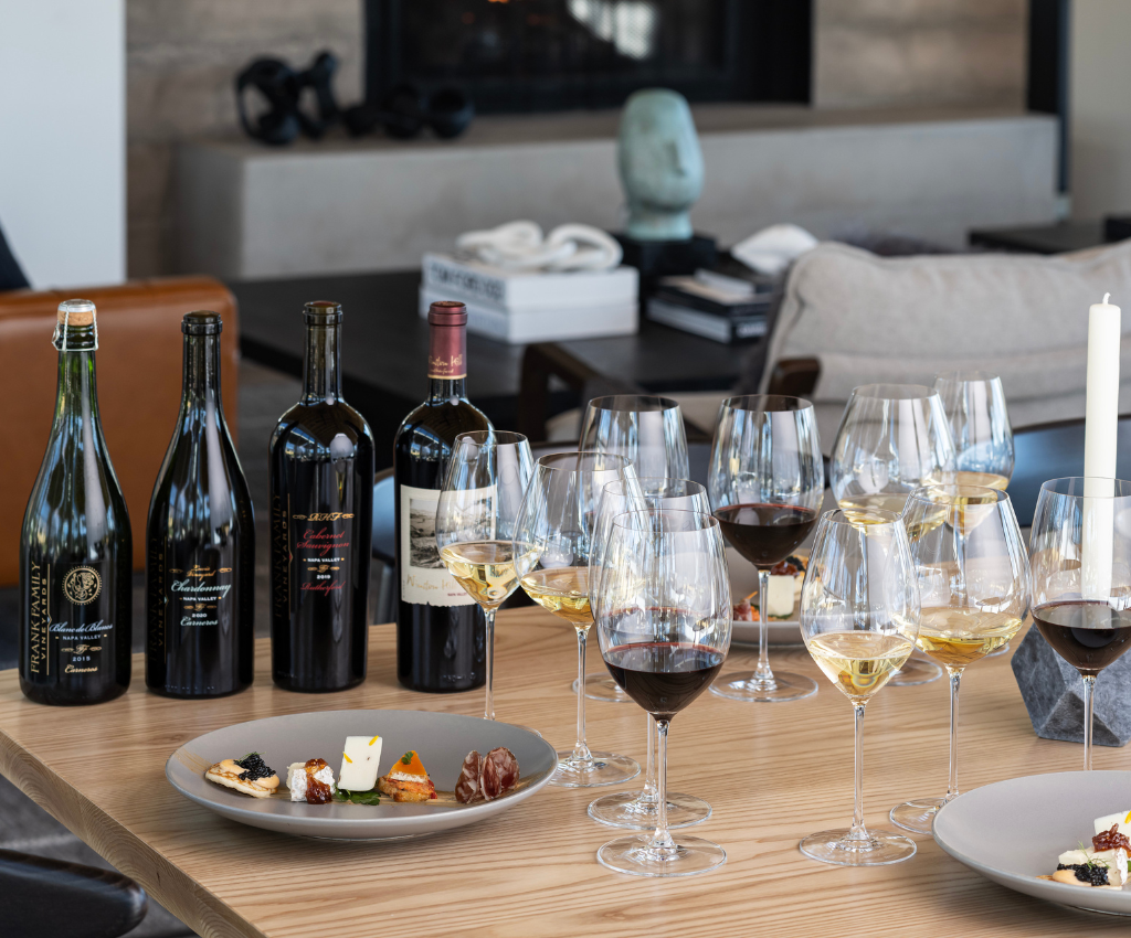 Various glasses of poured wine with snack plate.
