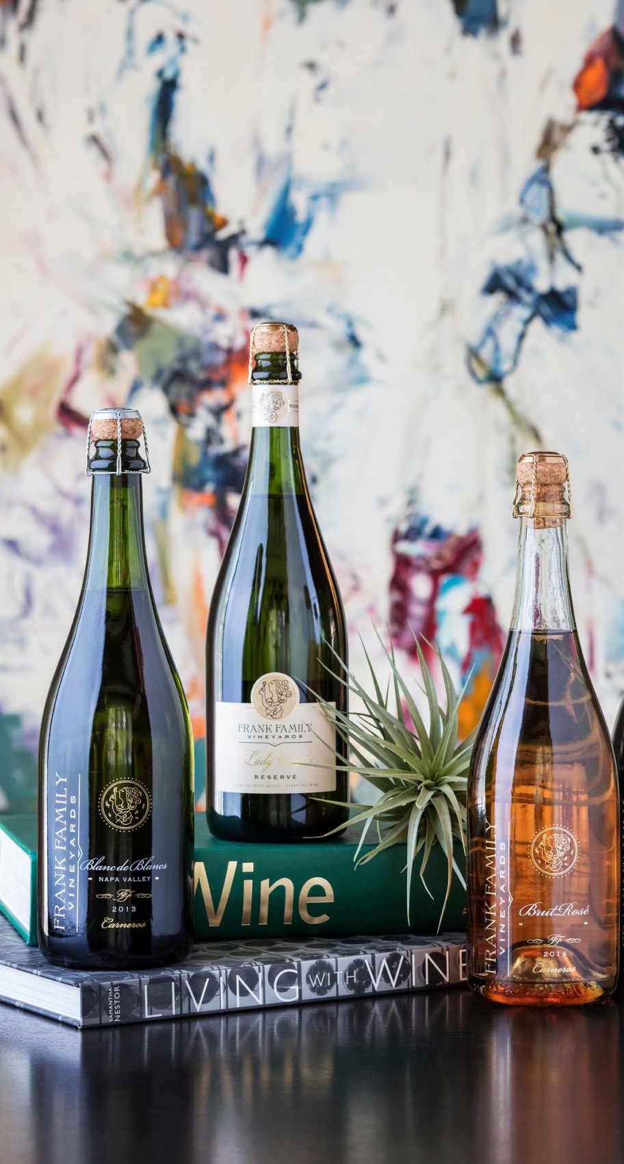 Closeup of several wine bottles, glasses, and decorative books.