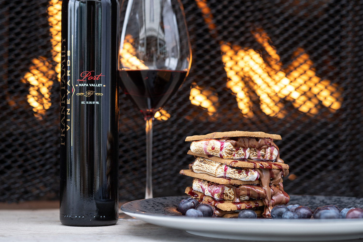 S'mores in front of a fire next to a bottle of Frank Family's Zinfandel Port