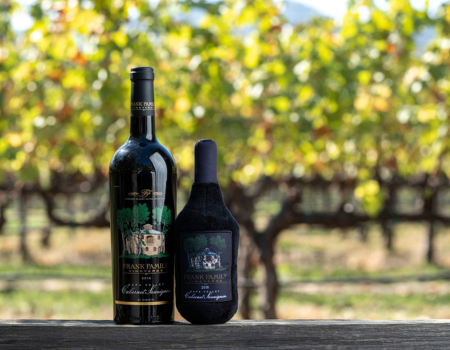 A bottle of Frank Family Cabernet Sauvignon beside a matching Cabernet plush dog toy
