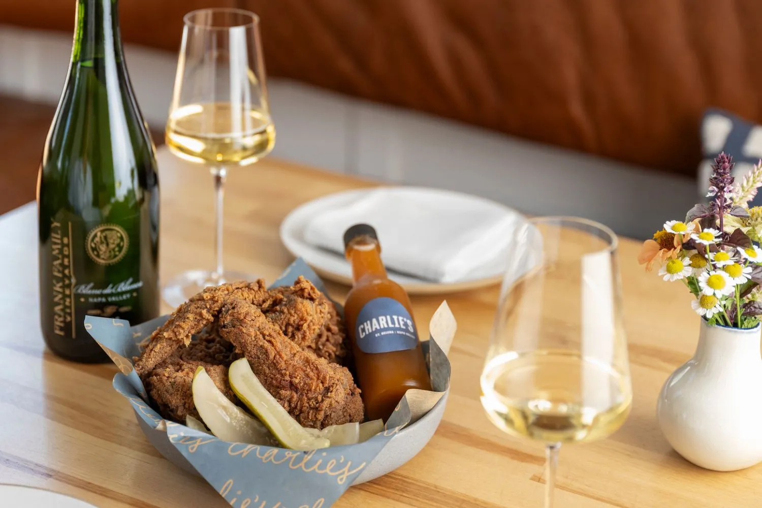 A bottle and glass of Frank Family's Blanc de Blancs alongside a dish of Fried Chicken from Charlie's restaurant in St. Helena.